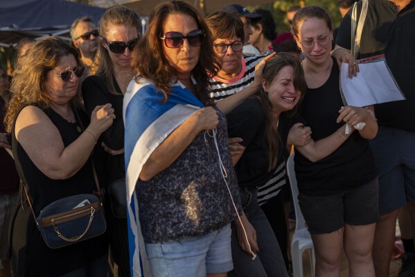Relatives attend the funeral of Albert Miles, 81, at the Kibbutz Revivim cemetery, south Israel, Monday, Oct. 30, 2023. Albert Miles was killed during the Hamas attack on Oct. 7, in Kibbutz Be'eri near the border with the Gaza Strip. (AP Photo/Bernat Armangue)