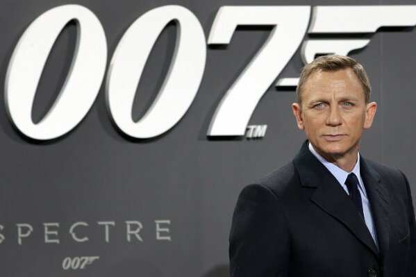 FILE - This is a Wednesday, Oct. 28, 2015 file photo of actor Daniel Craig poses for the media as he arrives for the German premiere of the James Bond movie "Spectre" in Berlin, Germany. The release of the James Bond film “No Time to Die” has been delayed again, this time to 2021, because of the effects of COVID-19 on the theatrical business. MGM, Universal and Bond producers, Michael G. Wilson and Barbara Broccoli, said on Twitter Friday that the 25th instalment in the franchise will now open globally on April 2, 2021. (AP Photo/Michael Sohn, File)