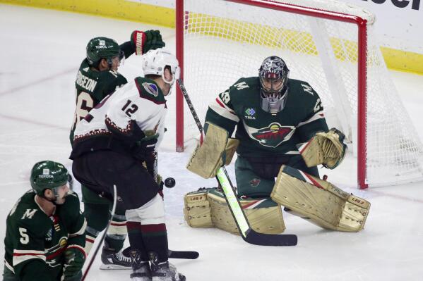 Minnesota Wild goaltender Marc-Andre Fleury (29) tracks a shot as Arizona Coyotes left wing Nick Ritchie (12) and Wild defenseman Jared Spurgeon (46) battle for position in the first period during an NHL hockey game Saturday, Jan. 14, 2023, in St. Paul, Minn. (AP Photo/Andy Clayton-King)