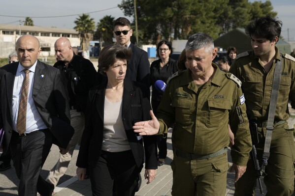 French Foreign Minister Catherine Colonna, center left, talks with Israeli Col. Olivier Rafowicz as she arrives at the Shura military base, central Israel Sunday Dec. 17, 2023. (AP Photo/Leo Correa)