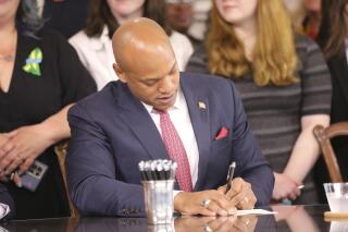 Maryland Gov. Wes Moore signs one of several gun-control measures during a bill-signing ceremony on Tuesday, May 16, 2023, in Annapolis, Md. One of the bills signed by the governor generally prohibits a person from wearing, carrying or transporting a gun into areas like schools or health care facilities. (AP Photo/Brian Witte)