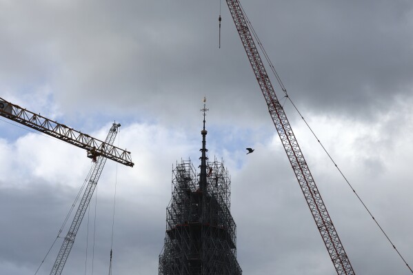 Scaffolding is being removed around the spire of Notre Dame de Paris cathedral, showing the rooster and the cross, Monday, Feb. 12, 2024 in Paris. Notre Dame is expected to reopen in Dec. 2024 following the devastating fire in April 2019. (APPhoto/Aurelien Morissard)