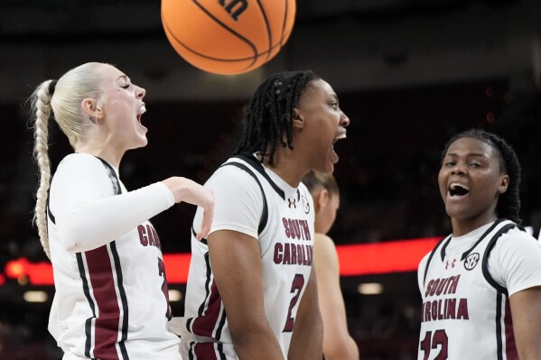 South Carolina forward Chloe Kitts, from left, forward Ashlyn Watkins and guard MiLaysia Fulwiley celebrates after scoring against Texas A&M during the second half of an NCAA college basketball game at the Southeastern Conference women's tournament Friday, March 8, 2024, in Greenville, S.C. (AP Photo/Chris Carlson)