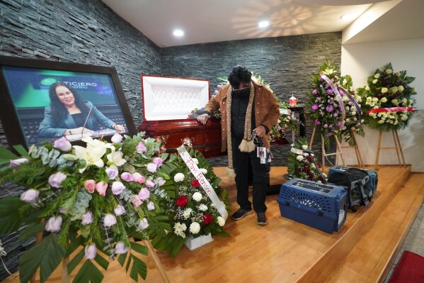 FILE - A friend pays his final respects to murdered journalist Lourdes Maldonado who was shot dead in her car when arriving home, in Tijuana, Mexico, Jan. 27, 2022. In the first month of 2022, two journalists were shot to death in two separate attacks in one week in Tijuana. (AP Photo/Marco Ugarte, File)
