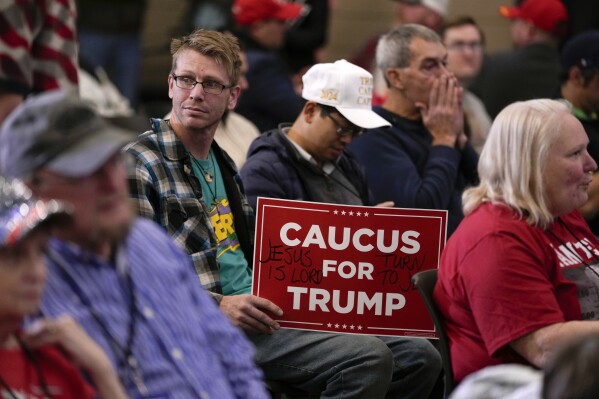 FILE - Audience members wait for former President Donald Trump to arrive at a commit to caucus rally, Tuesday, Dec. 19, 2023, in Waterloo, Iowa. (AP Photo/Charlie Neibergall, File)