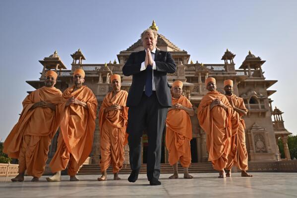Britain's Prime Minister Boris Johnson, center, poses with Sadhus, or Hindu holy men, in front of the Swaminarayan Akshardham temple, in Gandhinagar, part of his two-day trip to India, Thursday, April 21, 2022. (Ben Stansall/Pool Photo via AP)