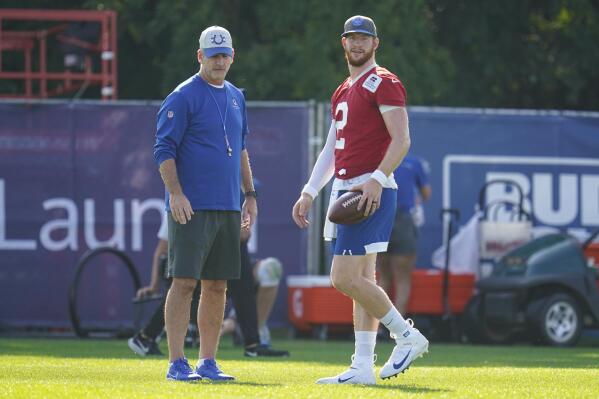 Indianapolis Colts quarterback Carson Wentz (2) talks with head coach Frank Reich during practice at the NFL team's football training camp in Westfield, Ind., Monday, Aug. 23, 2021. (AP Photo/Michael Conroy)