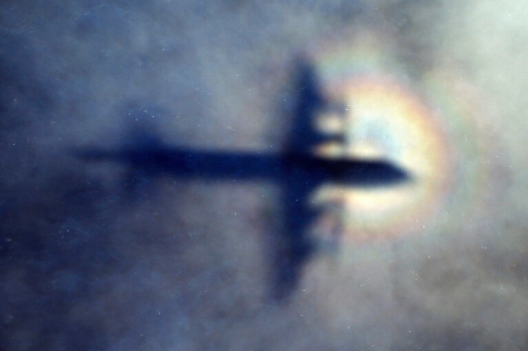 FILE - The shadow of a Royal New Zealand Air Force P3 Orion is seen on low level cloud while the aircraft searches for missing Malaysia Airlines Flight MH370 in the southern Indian Ocean, near the coast of Western Australia, on March 31, 2014. A decade ago this week, a Malaysia Airlines flight vanished without a trace to become one of aviation's biggest mystery. Investigators still do not know exactly what happened to the plane and its 239 passengers. (AP Photo/Rob Griffith, File)