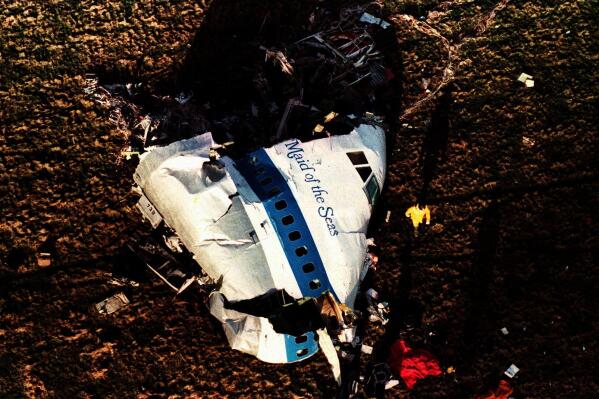 FILE Police and investigators look at what remains of the nose of Pan Am 103 in a field in Lockerbie, Scotland, in this Dec. 22, 1988 file photo. U.S. and Scottish authorities said Sunday, Dec. 11, 2022 that the Libyan man suspected of making the bomb that destroyed a passenger plane over Lockerbie, Scotland, in 1988 is in U.S. custody. (AP Photo/Martin Cleaver, File)