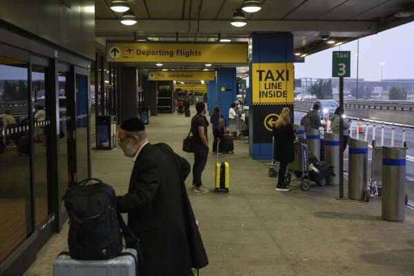 People wait for a taxi at the international terminal at Newark Liberty International Airport, Monday, June 9, 2025, in New Jersey. (AP Photo/Yuki Iwamura)