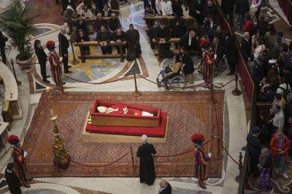 Faithful pay their respects to Pope Francis lying in state inside St. Peter's Basilica at the Vatican, Thursday, April 24, 2025. (AP Photo/Alessandra Tarantino)