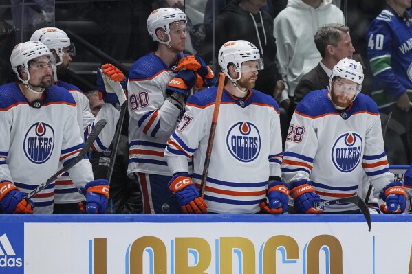 Edmonton Oilers' Cody Ceci, Corey Perry, Brett Kulak and Connor Brown, from left, stand on the bench during the final seconds in Game 5 of the team's NHL hockey Stanley Cup second-round playoff series against the Vancouver Canucks, Thursday, May 16, 2024, in Vancouver, British Columbia. (Darryl Dyck/The Canadian Press via Ǻ)