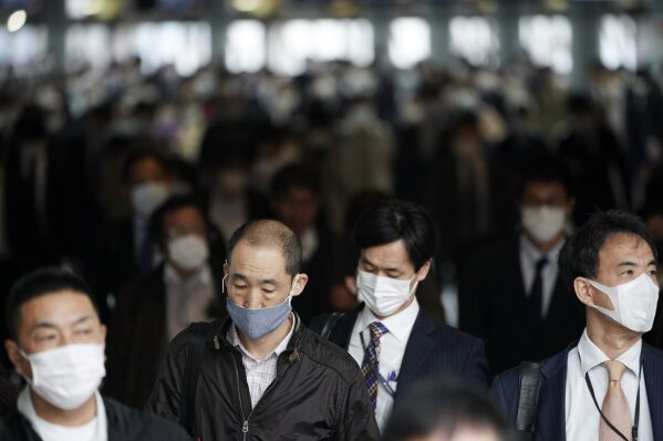 A station passageway is crowded with commuters wearing face mask during a rush hour in Tokyo Monday, April 27, 2020. Japan's Prime Minister Shinzo Abe expanded a state of emergency to all of Japan from just Tokyo and other urban areas as the virus continues to spread. (AP Photo/Eugene Hoshiko)