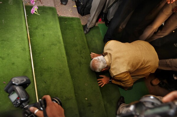 FILE - In this May 20, 2014 file photo, before being elected as prime minister for the first time, Hindu nationalist Bharatiya Janata Party (BJP) leader Narendra Modi, bends down on his knees on the steps of the Indian parliament building as a sign of respect as he arrives for the BJP parliamentary party meeting in New Delhi, India. Modi is campaigning for a third term in the general election starting Friday. (AP Photo/Manish Swarup, File)