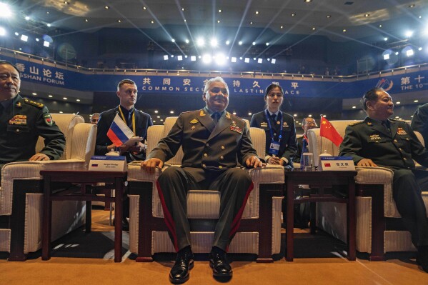 Russian Defense Minister Sergei Shoigu, center, takes a seat for the opening ceremony of the 10th Beijing Xiangshan Forum in Beijing, Monday, Oct. 30, 2023. Defense Minister Shoigu said Monday the United States is fueling geopolitical tensions to uphold its "hegemony" and warned of the risk of confrontation between major countries. (AP Photo/Ng Han Guan)