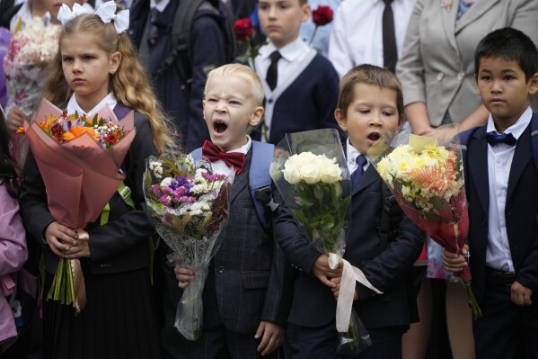 First graders take part in a ceremony marking the start of classes at a school as part of the traditional opening of the school year known as "Day of Knowledge" in St. Petersburg, Russia, Friday, Sept. 1, 2023. Many schools across the country reopen on Sept. 1. (AP Photo/Dmitri Lovetsky)