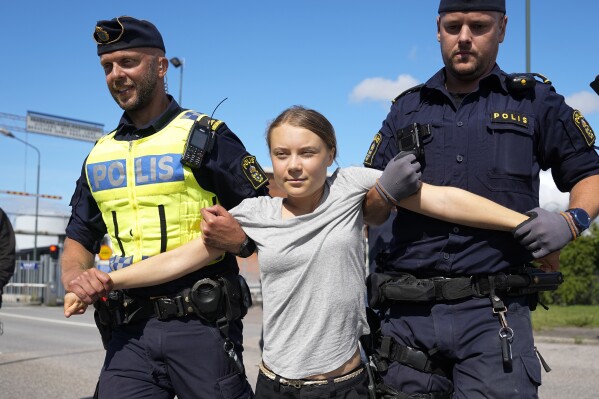 Climate activist Greta Thunberg is detained by police during an action for blocking the entrance to an oil facility in Malmo, Sweden, Monday, July 24, 2023. The protest took place just a few hours after Thunberg was fined for disobeying police during a similar protest last month at the same terminal. (AP Photo/Pavel Golovkin)
