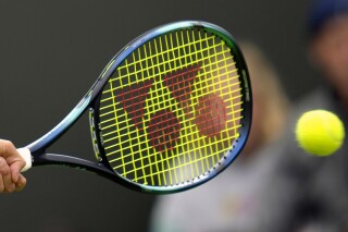 FILE - A racquet and ball during the Wimbledon tennis tournament in London, June 28, 2022. The Masters 1000 tournaments in Canada and Cincinnati will increase to 12 days each next season, and events in Dallas, Doha and Munich will be upgraded to the 500 level as part of changes announced by the ATP Tour. The men's tennis tour released its 2025 calendar on Friday, March 22, 2024. The calendar reveal comes as tennis is at something of a crossroads, with proposals to alter the way the sport is organized being discussed by its leaders. (AP Photo/Kirsty Wigglesworth, File)