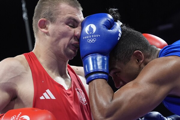 Ukraine's Oleksandr Khyzhniak, left, fights Cuba's Arlen Lopez in their men's 80 kg semifinal boxing match at the 2024 Summer Olympics, Sunday, Aug. 4, 2024, in Paris, France. (AP Photo/Ariana Cubillos)