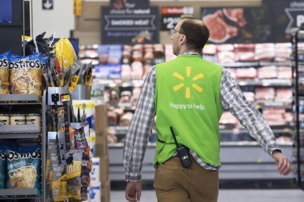 FILE - A Walmart associate works at a Walmart Neighborhood Market, Wednesday, April 24, 2019, in Levittown, N.Y.  The nation’s two major retailers _ Walmart and Target_ plan to push deals and other marketing gimmicks for the holiday shopping season earlier than last year as soaring inflation spurs customers to get a jump start on gift giving.   (AP Photo/Mark Lennihan, File)