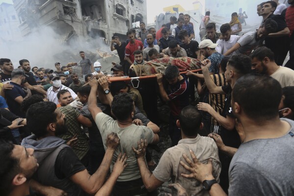 Palestinians remove a dead body from the rubble of a building after an Israeli airstrike Jebaliya refugee camp, Gaza Strip, Monday, Oct. 9, 2023. (AP Photo/Ramez Mahmoud )