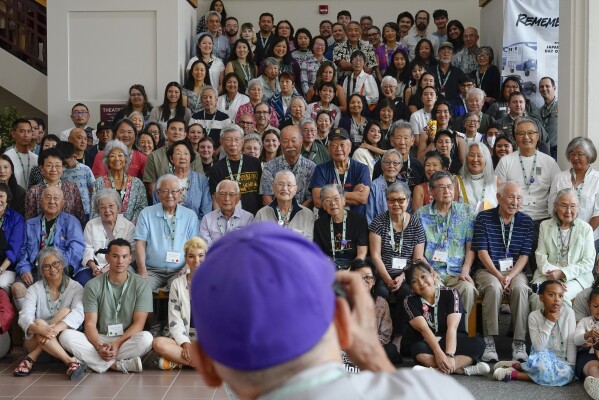 Minidoka survivor and pilgrimage planning committee member Eugene Tagawa sets up a large group photo of all pilgrimage attendees in a stairwell at the College of Southern Idaho, Friday, July 7, 2023, in Twin Falls, Idaho. (AP Photo/Lindsey Wasson)