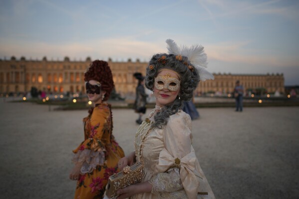 Arissa, right, and Eleanor of Britain arrive at the Great Masked Ball in Versailles, outside Paris, Saturday, June 21, 2025. (AP Photo/Christophe Ena)