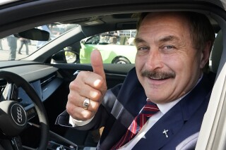 MyPillow chief executive and election denier Mike Lindell gives a thumbs up as he passes by a rally for supporters of former President Donald Trump, Tuesday, April 4, 2023, in West Palm Beach, Fla. Attorneys who've been defending Lindell against defamation lawsuits by voting machine companies have asked for court permission to quit, saying he owes them unspecified millions of dollars and can't pay the millions more that he'll owe in legal expenses going forward. (AP Photo/Wilfredo Lee)