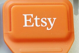 FILE - This Jan. 6, 2015 file photo shows an Etsy mobile credit card reader, in New York. Recent claims that listings of pizza photo downloads on the online marketplace  are a disguise for pedaling child pornography are baseless. (AP Photo/Mark Lennihan, File)