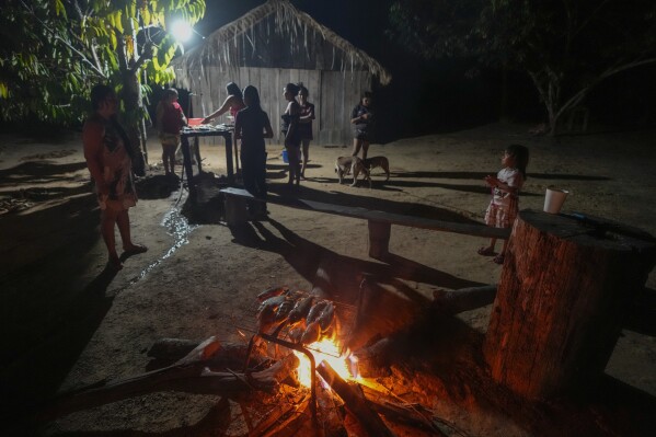 Juma Indigenous women prepare the day’s catch in their community, near Canutama, Amazonas state, Brazil, Saturday, July 8, 2023. The Juma seemed destined to disappear following the death of the last remaining elderly man, but under his three daughters’ leadership, they changed the patriarchal tradition and now fight to preserve their territory and culture. (AP Photo/Andre Penner)