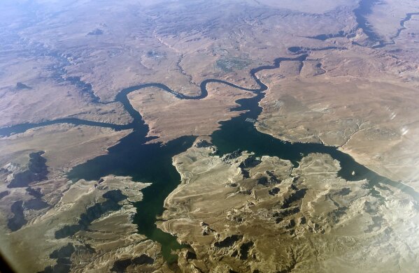FILE - In this Sept. 11, 2019, file photo, is an aerial view of Lake Powell on the Colorado River along the Arizona-Utah border. A set of guidelines for managing the Colorado River helped several states through a dry spell, but it's not enough to keep key reservoirs in the American West from plummeting amid persistent drought and climate change, according to a U.S. report released Friday, Dec. 18, 2020. (AP Photo/John Antczak, File)