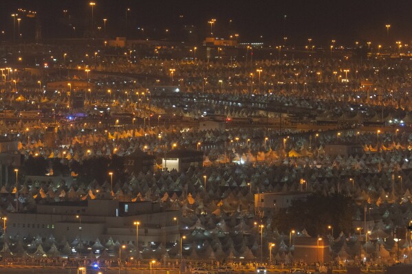 Muslim pilgrims walk back to their tents after casting stones at pillars in the symbolic stoning of the devil, the last rite of the annual hajj, in Mina, near the holy city of Mecca, Saudi Arabia, Monday, June 17, 2024. Muslim pilgrims used the early morning hours Monday to perform the second day of the symbolic stoning of the devil, as noontime summer heat caused heatstroke among thousands wrapping up the Hajj pilgrimage. (AP Photo/Rafiq Maqbool)