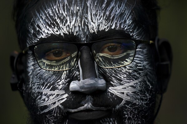 A visitor, his face painted to represent a zebra, eyes the camera during a parade marking the 100th anniversary of the Chapultepec Zoo, in Mexico City, Thursday, July 6, 2023. Zoo organizers invited visitors to come dressed as their favorite animal. (AP Photo/Fernando Llano)