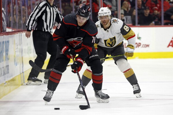 Carolina Hurricanes' Brady Skjei (76) controls the puck in front of Vegas Golden Knights' Jonathan Marchessault (81) during the first period of an NHL hockey game in Raleigh, N.C., Tuesday, Dec. 19, 2023. (AP Photo/Karl B DeBlaker)