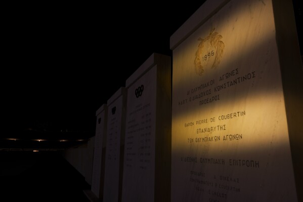 A marble sign which reads in Greek that Baron Pierre de Coubertin is the reviver of the Olympic Games stands inside the marble Panathinean Stadium, venue of the first modern Olympics in 1896, in Athens, early Thursday, Åpril 4, 2024. Born in 1863, Coubertin was the second president of the IOC — after Greece's Demetrios Vikelas — serving from 1896-1927. His tenure included the games held in Paris in 1900 and 1924.(AP Photo/Petros Giannakouris)