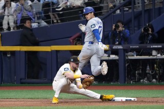 Los Angeles Dodgers designated hitter Shohei Ohtani, top, is forced out at first by San Diego Padres first baseman Jake Cronenworth during the seventh inning of an opening day baseball game at the Gocheok Sky Dome in Seoul, South Korea Wednesday, March 20, 2024, in Seoul, South Korea. (AP Photo/Ahn Young-joon)