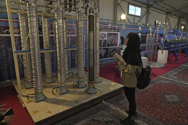 A student looks at Iran's domestically built centrifuges in an exhibition of the country's nuclear achievements, in Tehran, Iran, Wednesday, Feb. 8, 2023. The head of the United Nations nuclear watchdog on Tuesday underscored the urgency of resuscitating diplomatic efforts to limit Iran's nuclear program, saying the situation could quickly worsen if negotiations fail. (AP Photo/Vahid Salemi)
