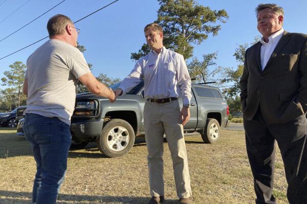 Republican Chris West, center, shakes hands with a voter on Oct. 6, 2022 at a campaign fundraiser in Georgetown, Ga. West, a Thomasville developer, is challenging 30-year incumbent Rep. Sanford Bishop, D-Ga., in southwest Georgia's 2nd Congressional District. (AP Photo/Jeff Amy)