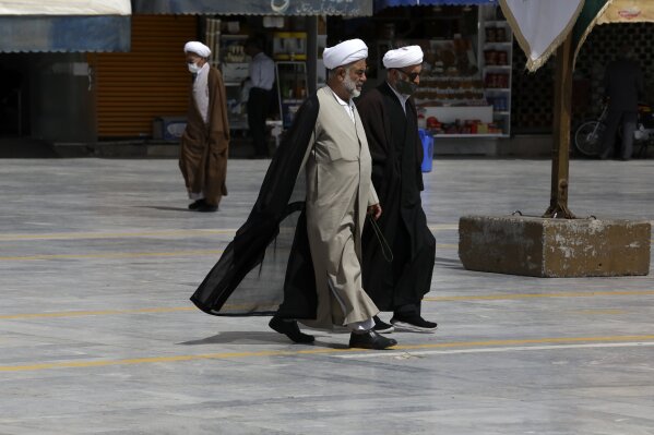 Clerics walk at the holy city of Qom, south of the capital Tehran, Iran, Tuesday, April 13, 2021, a day prior to start of the Muslim holy fasting month of Ramadan. (AP Photo/Vahid Salemi)