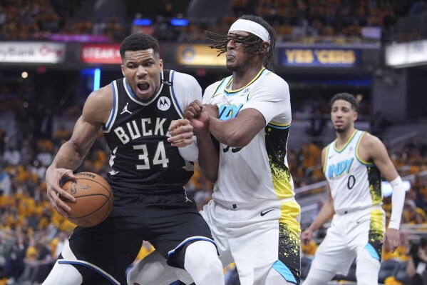 Milwaukee Bucks' Giannis Antetokounmpo (34) battles with Indiana Pacers' Myles Turner, right, during the second half of a first-round NBA basketball playoff game, Saturday, April 19, 2025, in Indianapolis. (AP Photo/Michael Conroy)