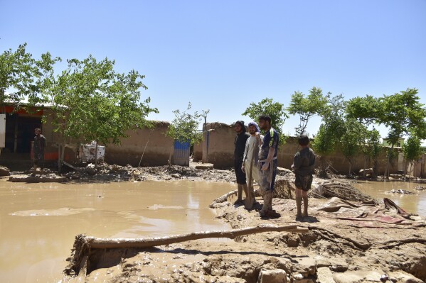 People stand near damaged homes after heavy flooding in Baghlan province, in northern Afghanistan, Sunday, May 12, 2024. Victims of the devastating floods in northern Afghanistan are burying the dead and looking for the loved ones still missing. (AP Photo)
