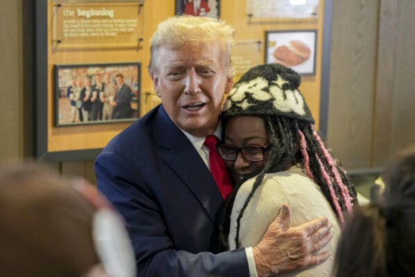 Republican presidential candidate former President Donald Trump, left, hugs Michaelah Montgomery, a local conservative activist, as he visits a Chick-fil-A eatery, Wednesday, April 10, 2024, in Atlanta. (AP Photo/Jason Allen)