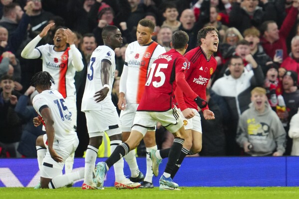 Manchester United's Victor Lindelof, right, celebrates after scoring his side's opening goal during the English Premier League soccer match between Manchester United and Luton Town at the Old Trafford stadium in Manchester, England, Saturday, Nov. 11, 2023. (AP Photo/Jon Super)