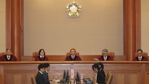 South Korea's Constitutional Court Chief Justice Yoo Nam-seok, top center, and other judges sit before the judgment at the Constitutional Court in Seoul, South Korea, Tuesday, July 25, 2023. South Korea's Constitutional Court on Tuesday overturned the impeachment of the public safety minister ousted over a Halloween crowd surge that killed nearly 160 people last October at a nightlife district in the capital, Seoul. (Yonhap via AP)