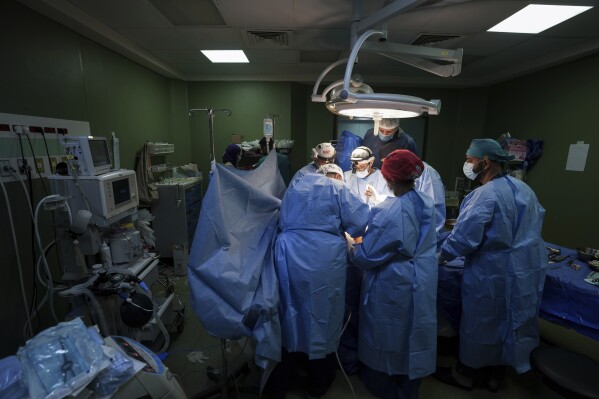 Doctors perform surgery on a patient at Al-Aqsa Martyrs Hospital, in Deir al-Balah, central Gaza. Sunday, March 17, 2024. (AP Photo/Abdel Kareem Hana)