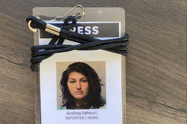 A press badge for Des Moines Register reporter Andrea Sahouri features her jail booking photo from her May 31, 2020 arrest while covering a Black Lives Matter protest. Sahouri is set to stand trial on Monday, March 8. 2021, on misdemeanor charges, a case that prosecutors have pursued despite international condemnation from advocates for press freedom. (Photo courtesy Andrea Sahouri via AP)