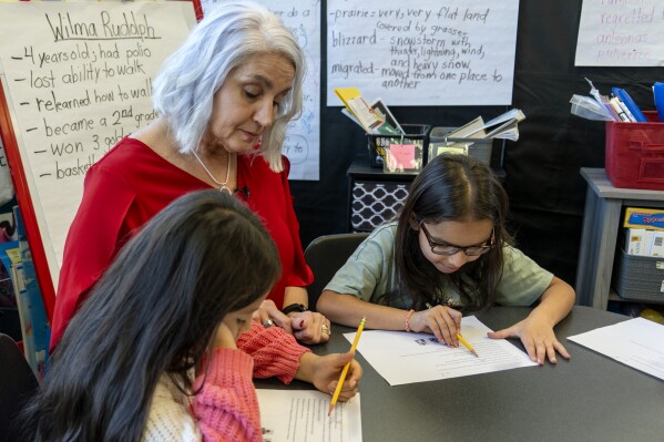 In this photo provided by the Tennessee Department of Education, 2nd grade teacher Missy Testerman, center, who teaches English as a second language, works with students Dafne Lozano, left, and Dwiti Patel, right, at the Rogersville City School, Thursday, March 13, 2024, in Rogersville, Tenn. Testerman has been named the 2024 National Teacher of the Year by the Council of Chief State School Officers. (Tennessee Department of Education via AP)