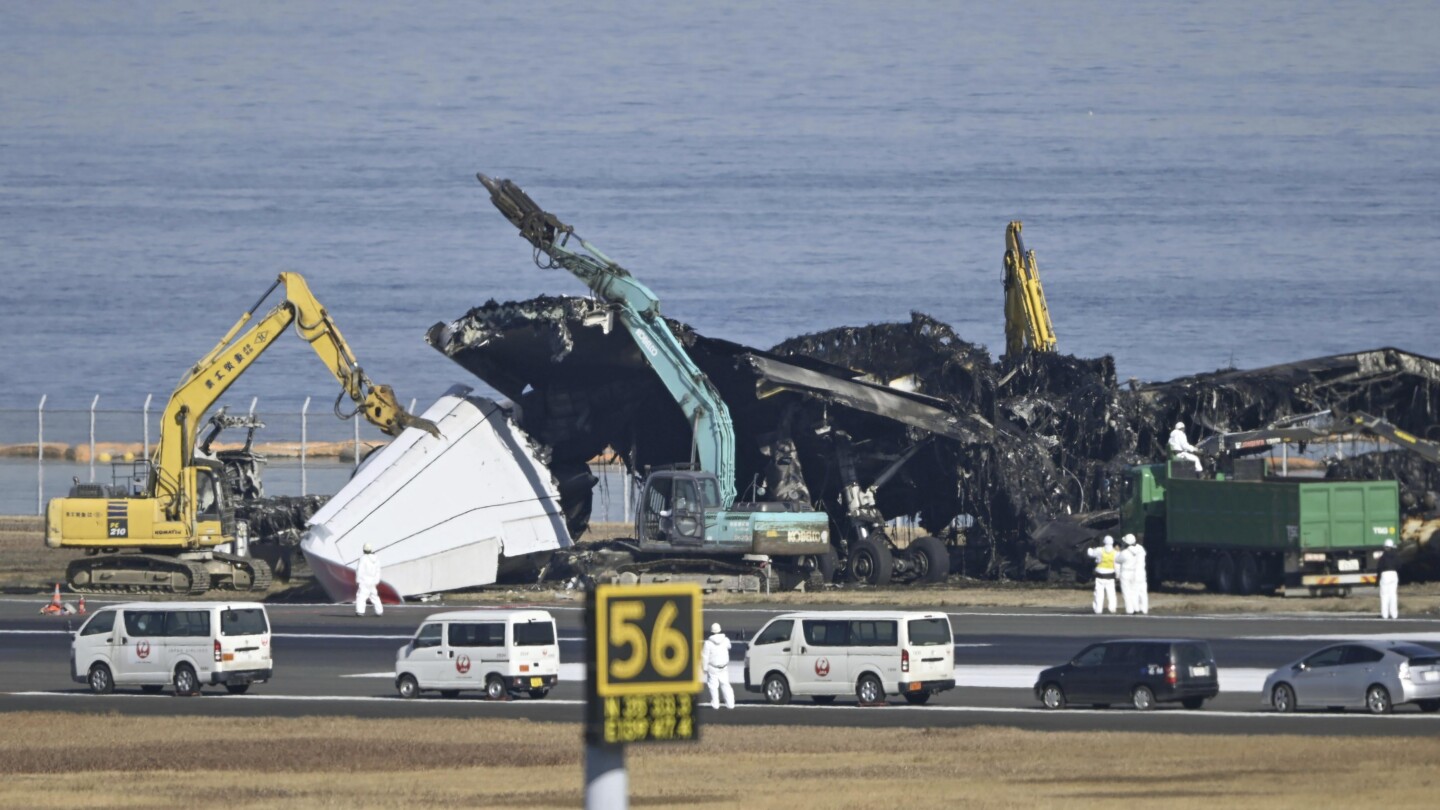 Expertos japoneses en defensa aérea buscan datos de voz entre los restos del avión después de que impactó en la pista.
