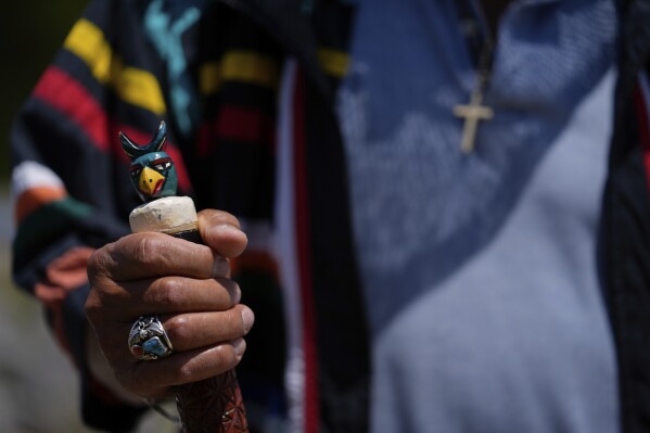 Miccosukee Tribal elder Michael Frank grasps his walking stick as he speaks with members of a task force that brings together federal, state, tribal and local agencies working to restore and protect the Florida Everglades, on a field visit to the Miccosukee Indian Reservation ahead of a task force meeting hosted by the Miccosukee Tribe, Wednesday, April 24, 2024. (AP Photo/Rebecca Blackwell)