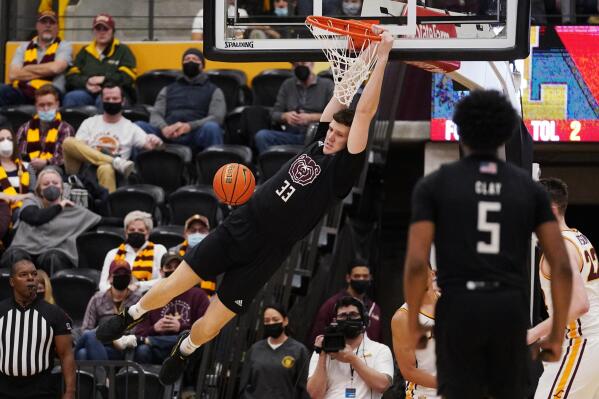 Missouri State center Dawson Carper (33) hangs from the rim after dunking against Loyola Chicago during the second half of an NCAA college basketball game in Chicago, Saturday, Jan. 22, 2022. (AP Photo/Nam Y. Huh)